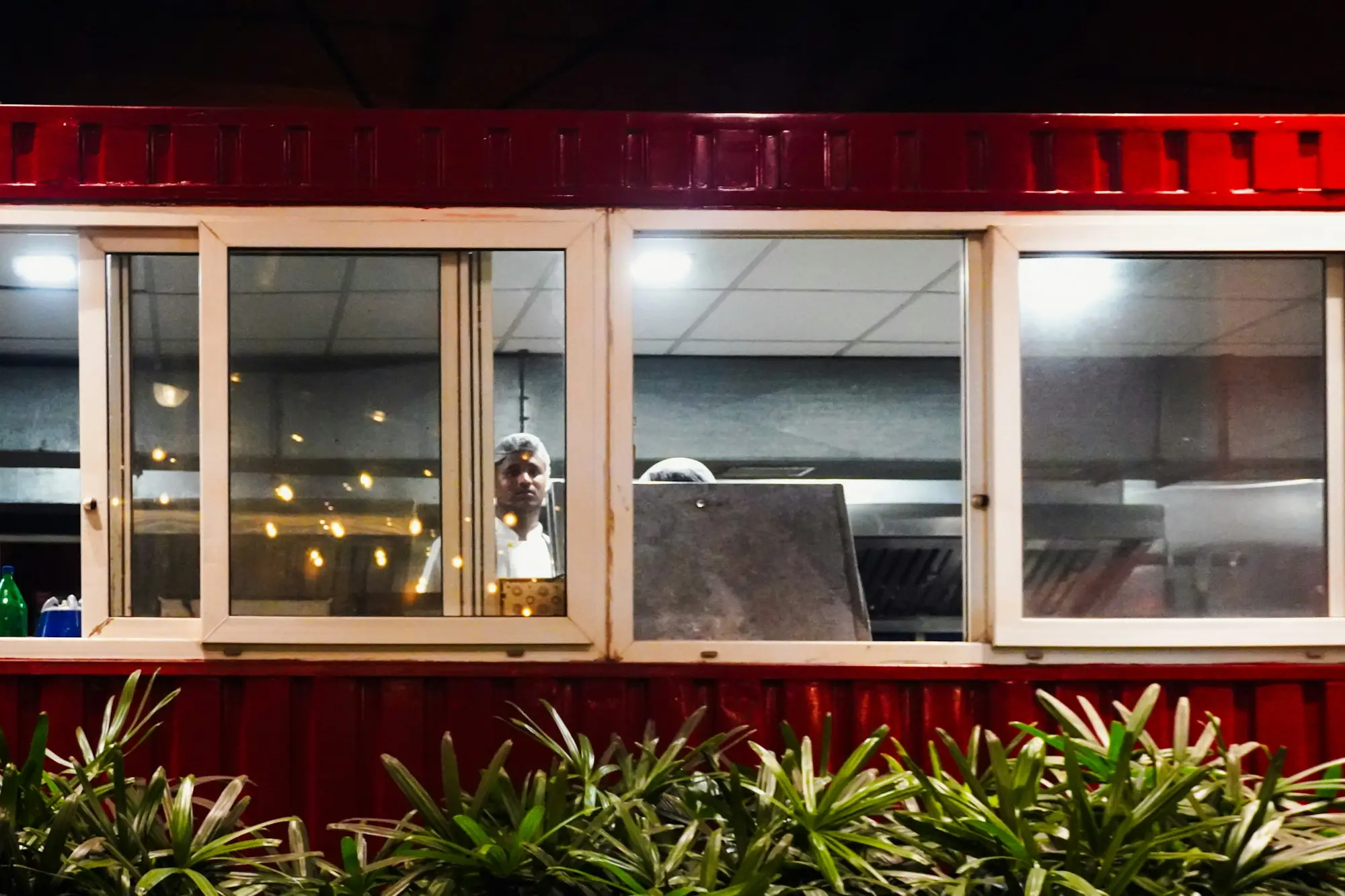 Food container kiosk with serving windows lit up at night