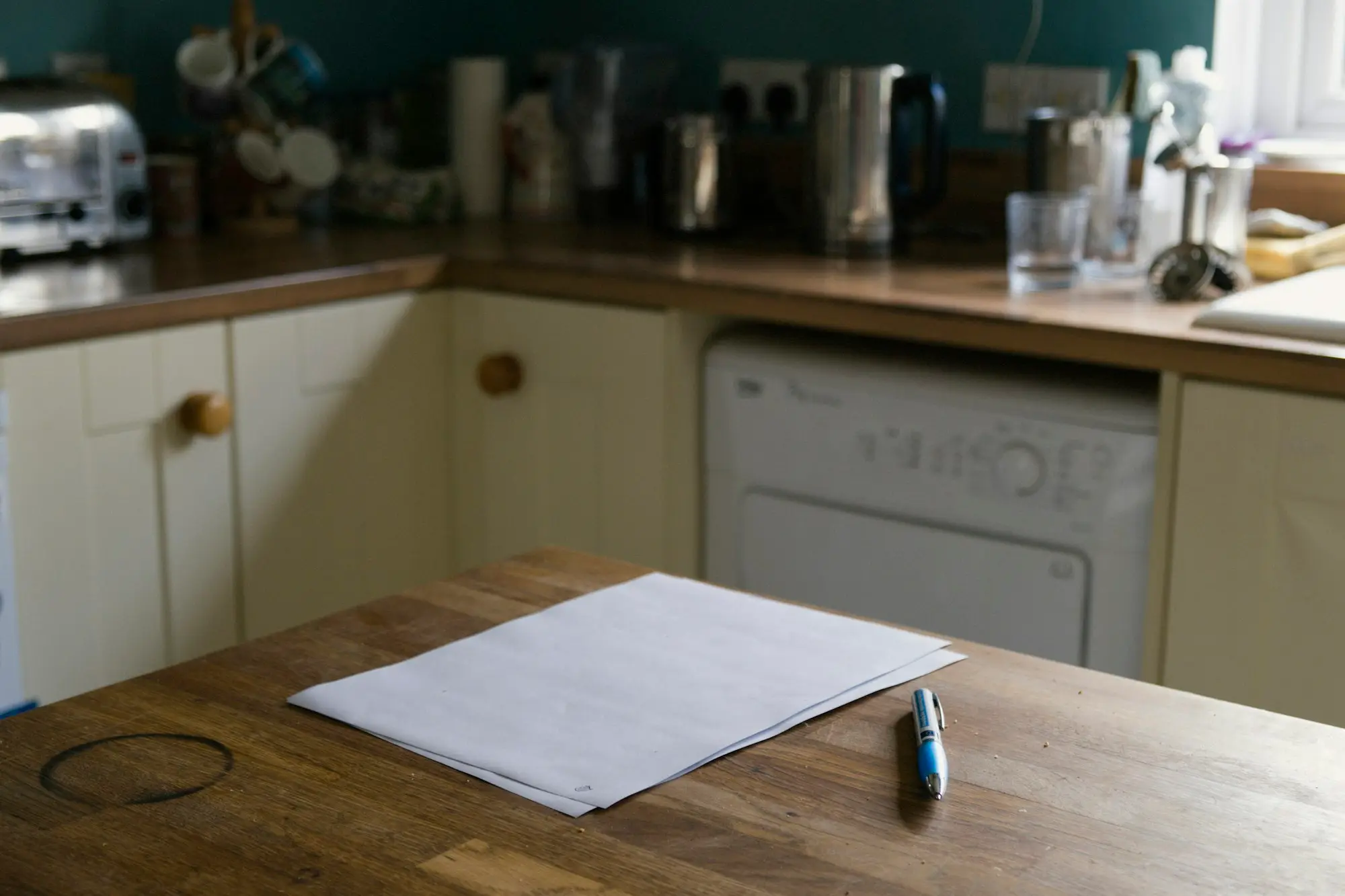 Permit paperwork and a pen laid out on a kitchen bench