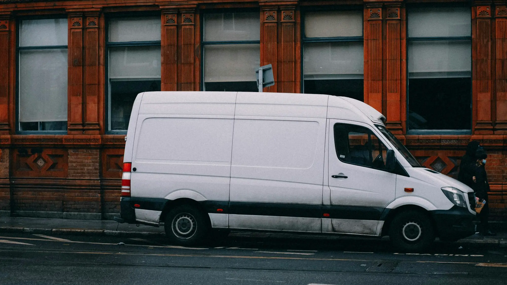 New white commercial van parked on a city street